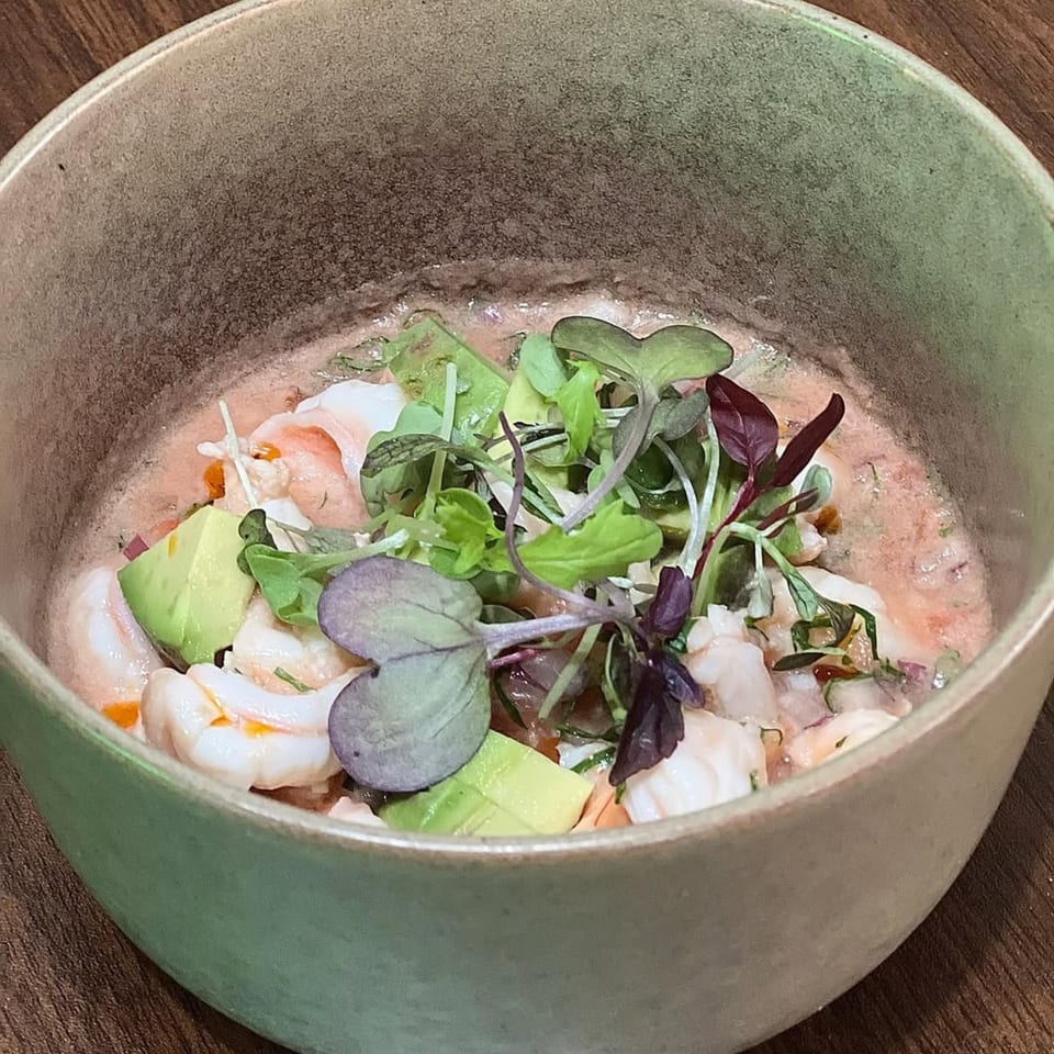 Chicatana's shrimp ceviche with avocado and microgreens in a rustic green bowl.